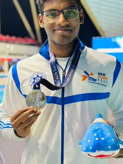 A close-up of champion swimmer Nithik Nathella proudly displaying his silver medal from the Asian Age Group Championships. His success is a result of talent combined with rigorous training and disciplined nutrition.
