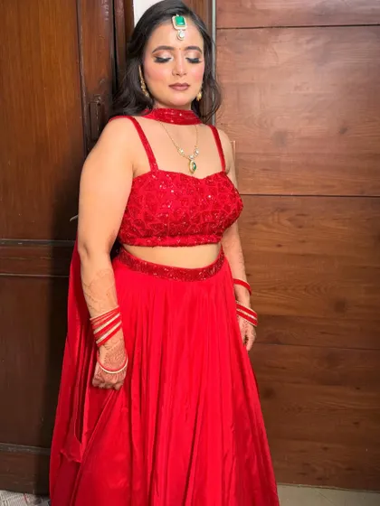 A full-length shot showcasing the simple elegance of the red lehenga.
