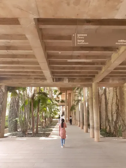 The iconic corridors of IIM Bangalore, designed by B.V. Doshi, where the line between building and landscape is blurred, with internal courtyards and greenery visible at every turn.