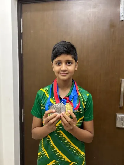 Shashwat Singh with his gold and silver medals from the Splash N' Dash competition, a result of his dedication to training.