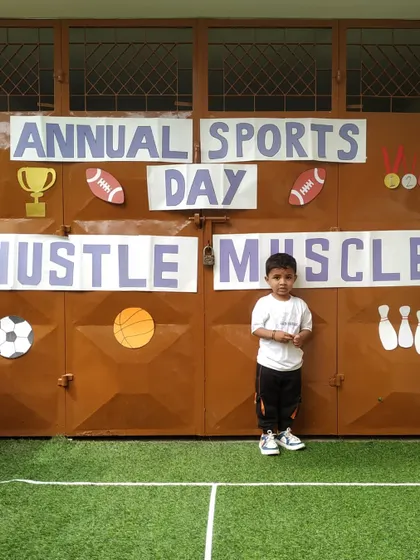 A young champion poses in front of our Annual Sports Day banner. We celebrate participation and effort from every single child.