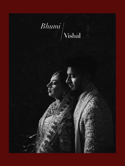 A powerful black and white portrait with deep shadows. The couple stands in a sliver of light, creating a dramatic and artistic image that highlights their profiles and the intensity of their connection.