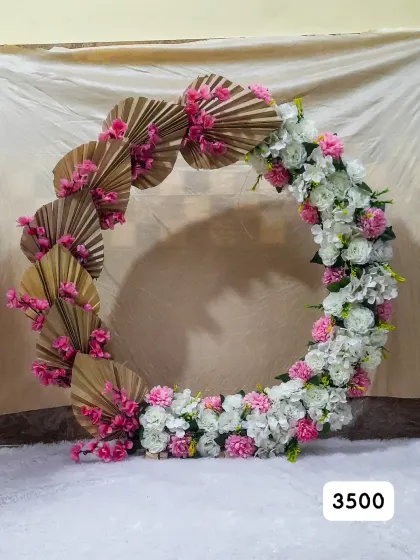 Our ready-made Ganpati ring combines pink and white artificial flowers with dried palm fans, advertised at ₹3,500.