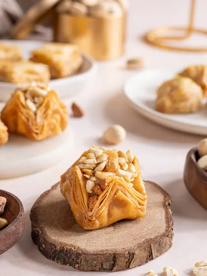 A close-up shot of a piece of baklava, focusing on its flaky layers and nutty filling, presented on a rustic wooden slice.
