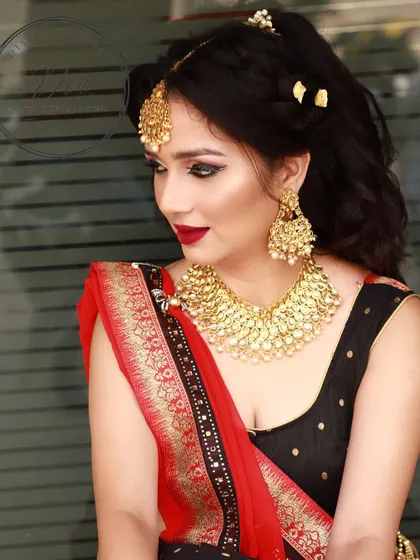 A bold and dramatic look featuring a heavy gold necklace and a classic red lip. The smokey eye makeup and contoured cheeks create a high-fashion, glamorous feel perfect for an editorial shoot.