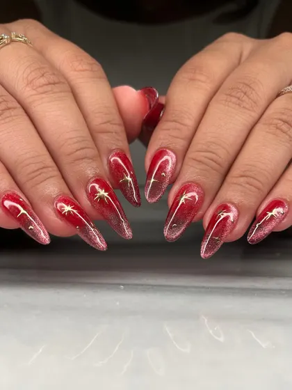 A fiery red cat-eye effect on long coffin nails. I added delicate gold star charms to this set for a touch of celestial magic against the deep, shimmering base.