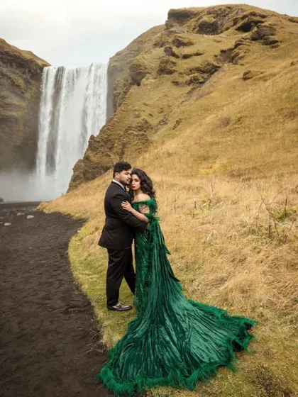 A romantic couple's portrait of Shree and Abhishek in Iceland. The contrast between her flowing green gown and his sharp black suit is pure cinematic elegance.