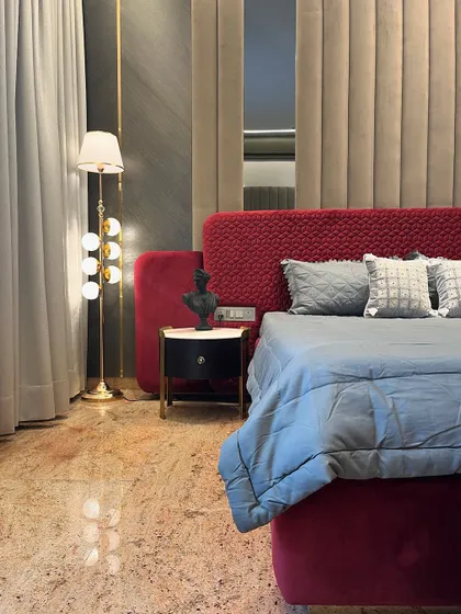 A closer look at the master bedroom's custom bed and side table. The rich texture of the quilted headboard contrasts with the smooth marble top of the bespoke, metal-legged nightstand.