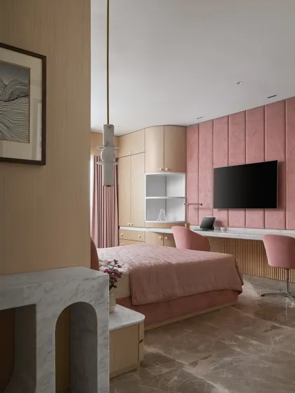 The kid's bedroom was designed around a request for 'bright pink'. We balanced the vibrant hue with soft wood tones and curved furniture, creating a playful yet sophisticated space with a large, shared study desk.