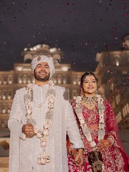 As confetti rains down against the backdrop of an illuminated palace, the couple shares their first moments as husband and wife. This is the kind of fairytale ending that marks a beautiful beginning, a memory of pure joy from a destination wedding in Jaipur.
