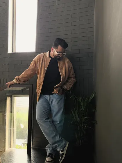 A relaxed, stylish pose in a tan jacket and jeans. This is my go-to look for casual client meetings or scouting a venue.