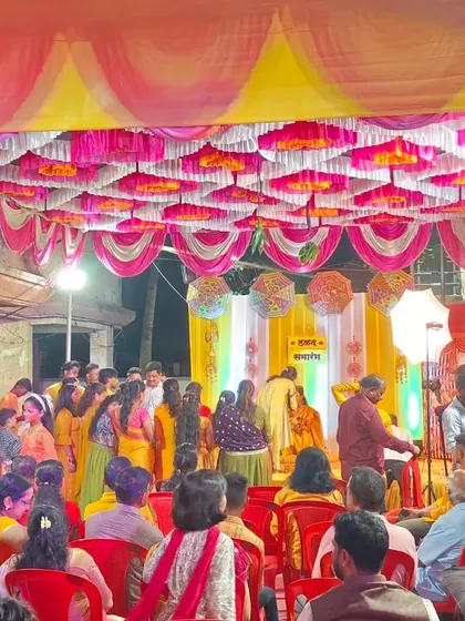 A full view of a lively Haldi ceremony in progress. You can see the colorful pandal ceiling, the stage, and the guests enjoying the function. I can manage events of all sizes.