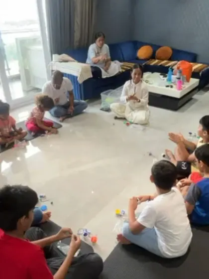 A wider view of our workshop in Chennai. Children are gathered in a circle, fully engaged in building their dough lights and greeting cards in a comfortable home setting.
