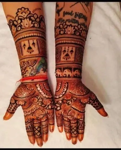 This intricate design includes the groom's name 'Tanveer' on the palm and a 'soul sisters' quote on the forearm, making it deeply personal for the bride.