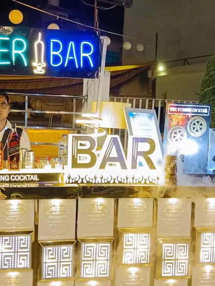 A clear view of one of our popular 'Shooter Bar' setups, featuring a custom neon sign and a well-lit bar front that attracts guests.