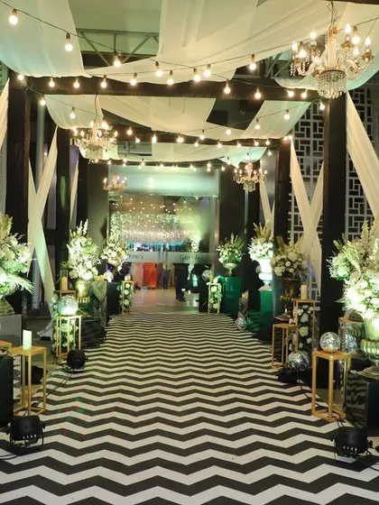 For a modern and chic Sangeet night, I designed this entrance with a bold black and white chevron walkway. The path is lined with glamorous disco balls and dramatic floral arrangements, setting a high energy tone for the party.