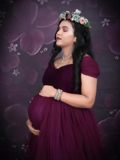A serene, eyes-closed pose in a wine-colored gown with a floral headpiece. This type of portrait beautifully captures the peaceful and inward-looking moments of pregnancy.