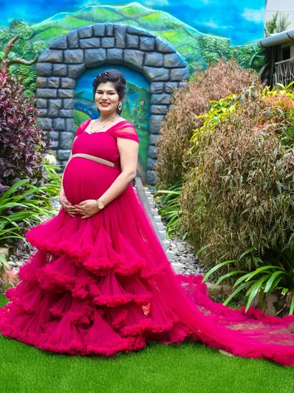 This couple chose a vibrant pink gown for their outdoor shoot. The garden location with its stone archway provides a lovely fairytale setting.
