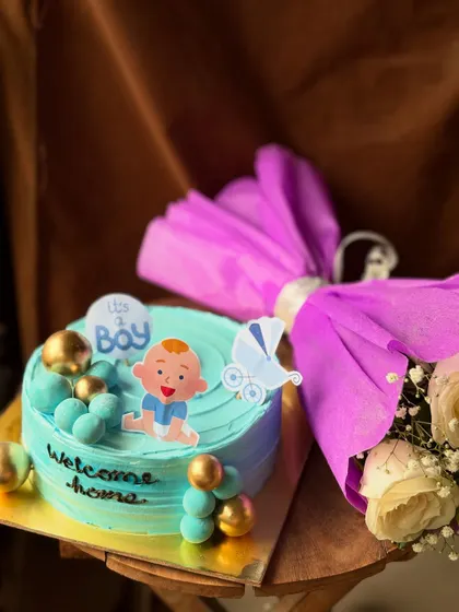A beautiful blue cake to celebrate the arrival of a baby boy. This gift set pairs the decorated cake with a bouquet of fresh flowers wrapped in purple paper.