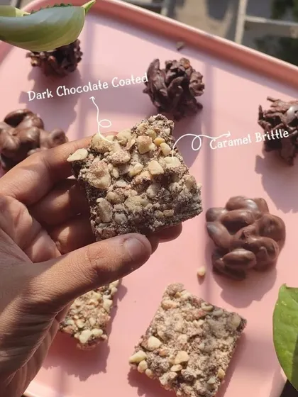 A close-up of my Almond Brittle. It's a crunchy caramel brittle loaded with almonds and coated in dark chocolate, offering a satisfying snap with every bite.