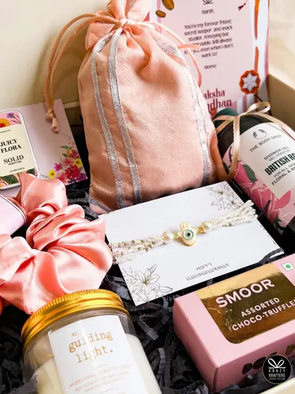 The 'Bandhu' Rakhi hamper for a sister, filled with pampering items like The Body Shop shower gel, a scented candle, chocolates, and an evil eye rakhi.