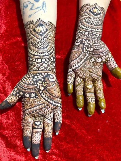 The full view of the bold and beautiful engagement mehendi, with a heart hidden in the palm.