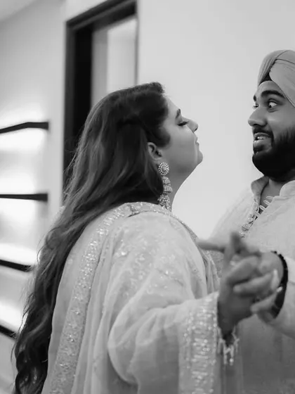 A playful moment captured in black and white. This candid shot shows the fun and lighthearted side of the couple's relationship during their celebration.