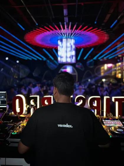 Focused on the mix. This perspective shows the concentration it takes to blend tracks perfectly and guide the energy of the room.