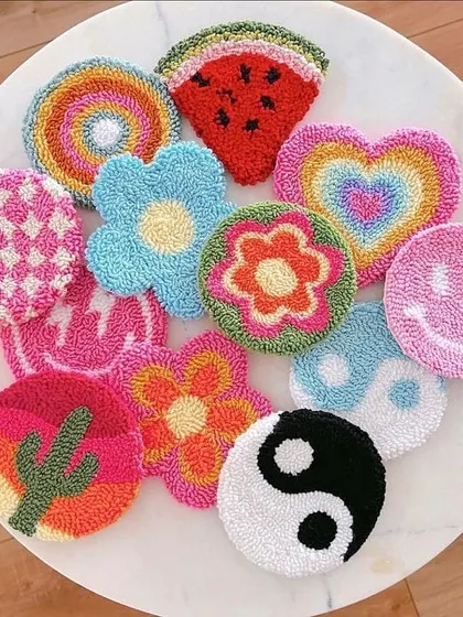 Look at this vibrant collection of punch needle coasters! Each one has a unique, fun design, from smiley faces and yin-yangs to rainbows and watermelons. They are perfect for adding a pop of color to any room.