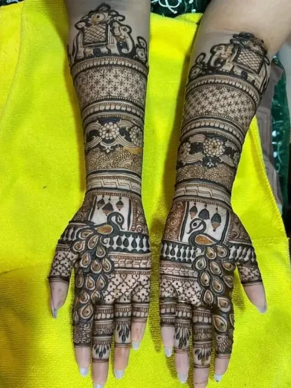 This full-arm bridal design showcases our expertise in traditional motifs. Notice the symmetrical patterns, the detailed elephants on the forearm, and the graceful peacocks on the palms.
