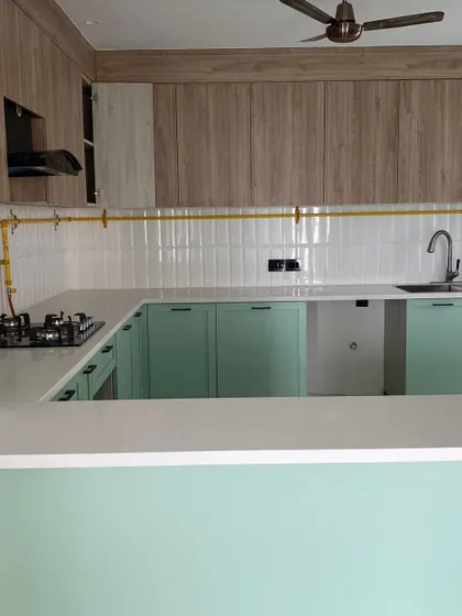 The finished pistachio kitchen, now with a countertop, sink, and gas pipeline installed. The combination of mint green and wood-laminate cabinets creates a fresh and modern culinary space.