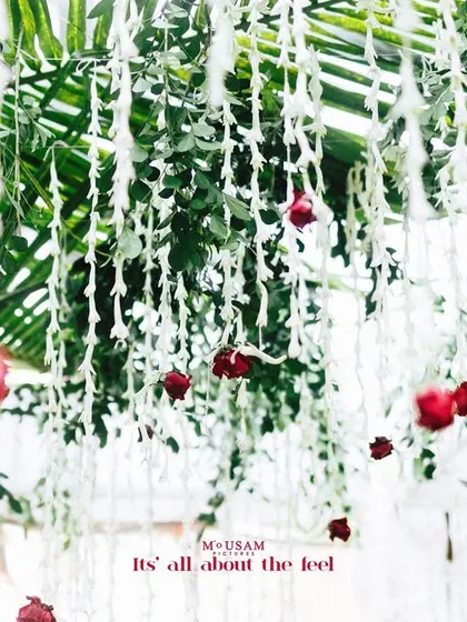 A beautiful decor detail of hanging white and red flowers. This simple yet elegant decoration adds a touch of romance and beauty to the wedding venue.