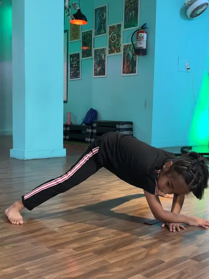 A student holding a plank variation, building core strength which is essential for balance and powerful movements.