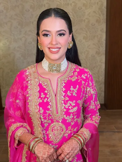 A smiling portrait of our bride for her Ghari Puja. The soft pink glam and sleek hair give her a look of pure grace.