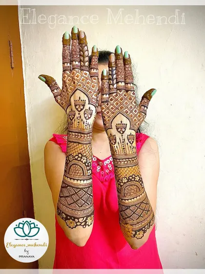 A full backhand bridal mehendi design with intricate patterns extending all the way up the arms.
