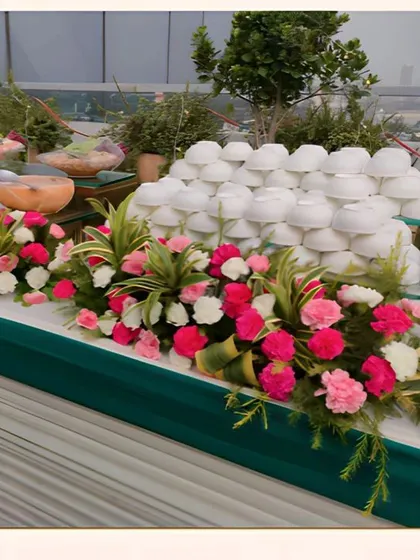 A closer view of our salad and cold appetizers station. The table is decorated with an abundance of fresh pink and white carnations, adding a touch of natural beauty to the food display.
