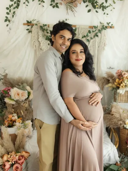 A happy and bright couple's portrait. Their coordinated neutral outfits blend perfectly with the earthy tones of the studio, creating a harmonious image.