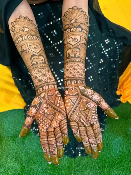 A beautiful bridal design with peacocks on the palms and forearms, along with elephant figures and the couple's initials.