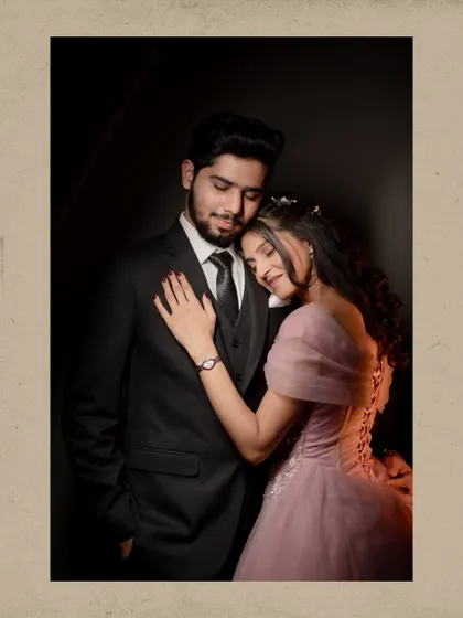 A romantic portrait of the couple embracing in a studio setting, with the bride resting her head on the groom's chest.
