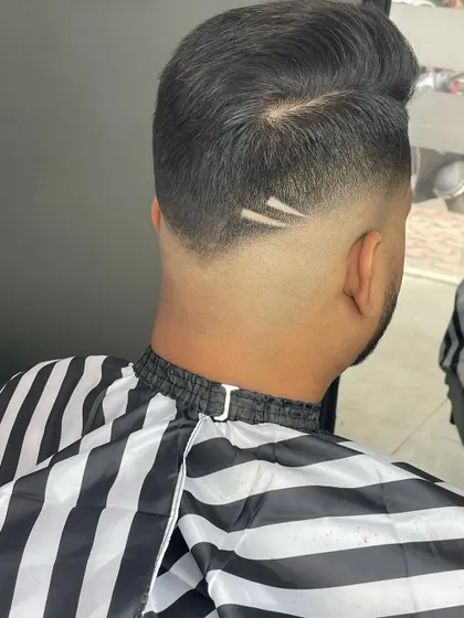 The back view of a skin fade, showing how a simple two-line design can add a unique signature to the haircut. The V-shaped nape keeps the look sharp.