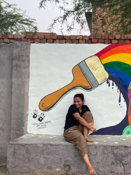 A moment of joy after completing a section of a community mural. The rainbow from the paintbrush symbolizes the magic and color art brings to a space.
