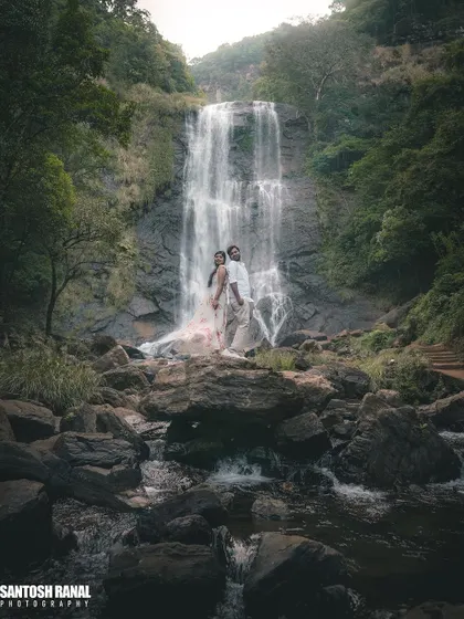 A wide-angle shot that captures the grand scale of the waterfall, with the couple at the heart of the landscape. This showcases our ability to blend epic scenery with intimate moments.