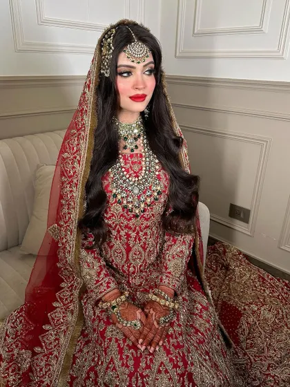 A side profile showcasing the beautiful maang tikka and the cascading layers of the bridal necklace. This look is all about royal elegance for your special day.