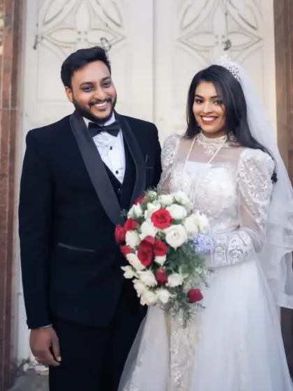 A happy couple on their wedding day. The bride is glowing in her beautiful rental gown, a testament to the fact that you don't need to buy to look breathtaking.