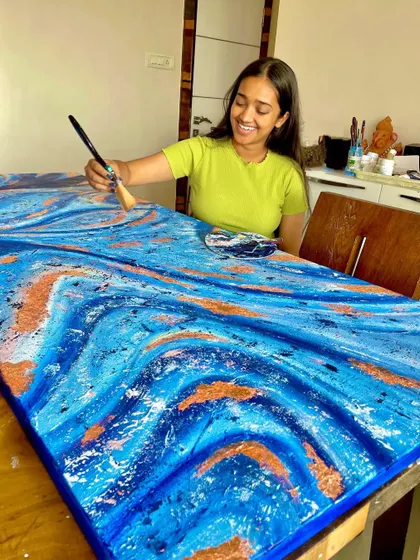 In my happy element, adding the finishing touches to a blue and gold abstract canvas. The palette knife is one of my favorite tools for creating texture.