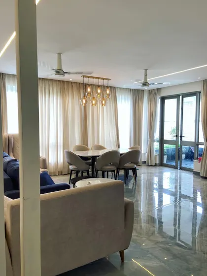 A wide shot of the Noida living and dining space, showing how the open layout is perfect for modern family living and entertaining.