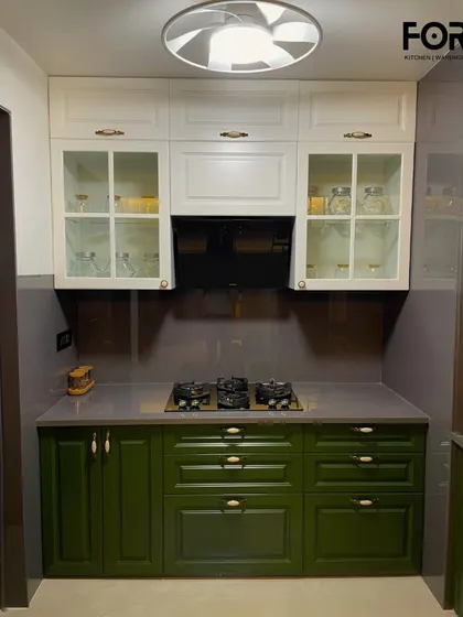 A frontal view of the cooking area in this classic kitchen. The paneled glass doors on the upper cabinets are perfect for displaying glassware, while the rich green of the base cabinets provides a warm, inviting feel.