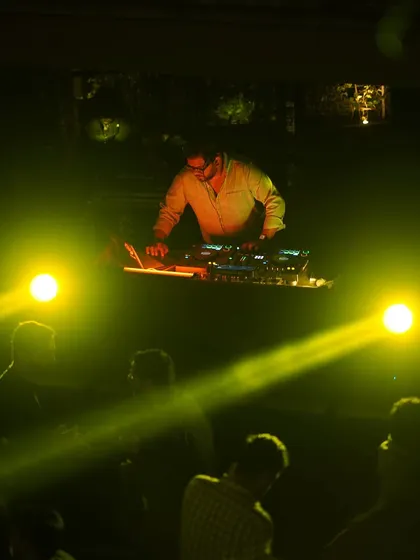 A shot of me at the decks, surrounded by yellow lights. Perfection boosts the ego, not happiness.