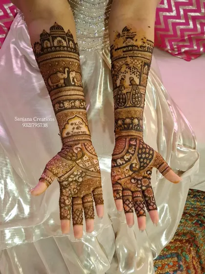A full bridal mehndi design fit for a queen. This intricate artwork features traditional motifs like elephants and palace architecture, covering the arms from fingers to elbow for a truly royal wedding look.