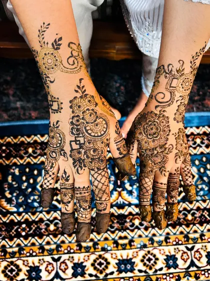 A lovely custom Arabic design that combines traditional paisleys with delicate floral vines. The fingertips have simple patterns, leaving some skin showing for a modern touch.